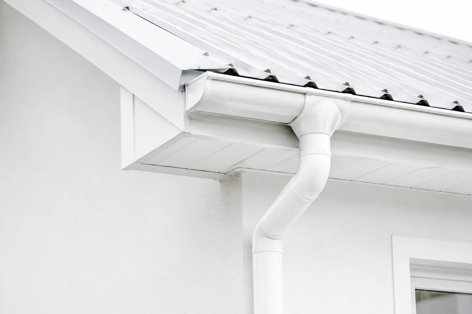 Modern roof gutter and downpipe system installed on a residential property.